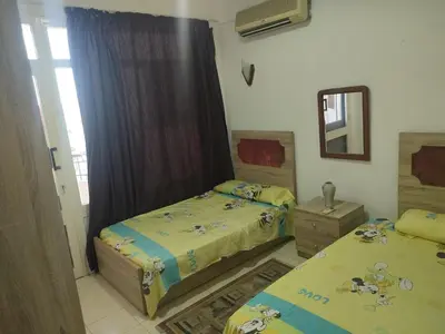 a bedroom with two beds and a mirror at Apartment Sama Beach in Hurghada