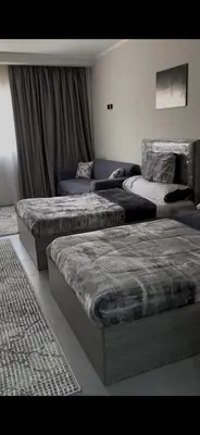 a room with three beds and a couch at غرفة فندقية in Hurghada