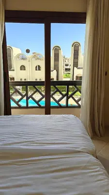 a bedroom with a bed and a window with a view at Sahl Hasheesh Aparthotel Beachfront - SAHLHOMES in Hurghada