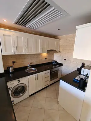 a kitchen with a sink and a washing machine at Sahl Hasheesh Aparthotel Beachfront - SAHLHOMES in Hurghada
