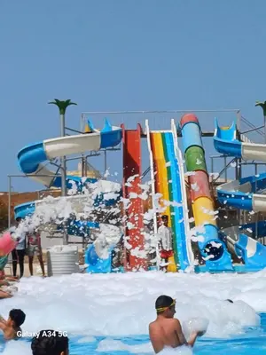 a water park with a water slide and people in the water at Luxury suit with private beach and aquapark in Hurghada