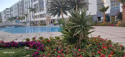 a courtyard with flowers and a pool in a building at Luxury suit with private beach and aquapark in Hurghada