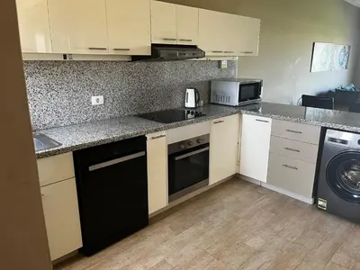 a kitchen with white cabinets and a black dishwasher at El Gouna Joubal Villa #2 with Private Garden and Lagoon View in El Gouna