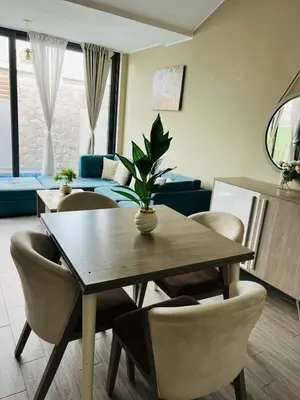 a living room with a wooden table and chairs at شاليه بالي بمسبح خاص مدفأ in Hurghada