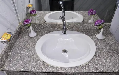 a bathroom counter with two sinks and purple flowers at Oscar Hotel Aswan \u4e2d\u570b\u4eba\u4e4b\u5bb6 in Aswan