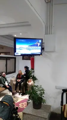 two people sitting in a room with a tv on the wall at Oscar Hotel Aswan \u4e2d\u570b\u4eba\u4e4b\u5bb6 in Aswan