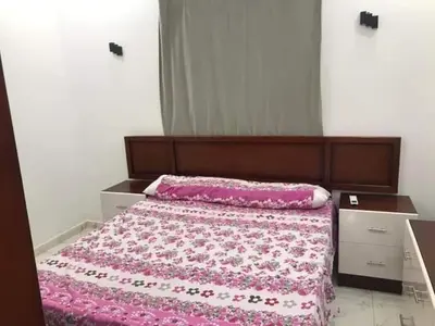 a bedroom with a bed with a pink blanket at Premier group in Hurghada