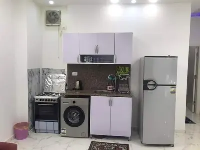 a kitchen with a refrigerator and a washing machine at Premier group in Hurghada