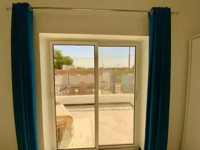 a sliding glass door with a view of a balcony at Jasmine Villa in Jazīrat al ‘Awwāmīyah