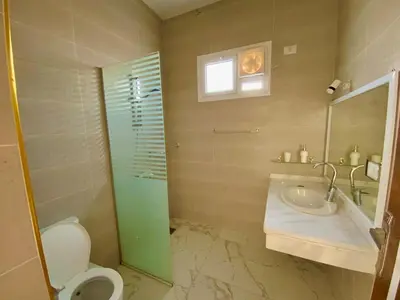 a bathroom with a toilet and a sink and a mirror at Jasmine Villa in Jazīrat al ‘Awwāmīyah