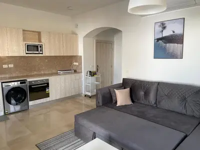 a living room with a couch and a kitchen at Azzura Sahl Hasheesh in Hurghada