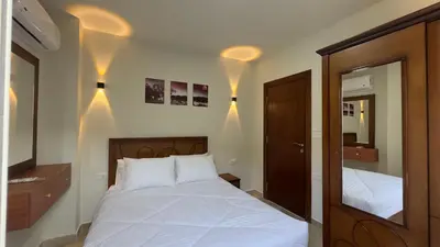 a bedroom with a white bed and a mirror at El princess one bedroom hurghada in Hurghada