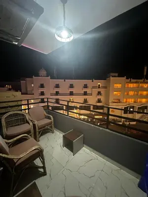 a balcony with chairs and a table on a building at 2 bedroom apartment in Prestige Plaza in Hurghada