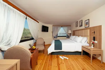 a hotel room with a bed and a large window at Shepherd I Dahabya in Esna
