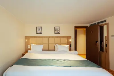 a bedroom with a large bed with white sheets at Shepherd I Dahabya in Esna