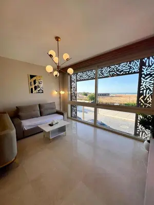 a living room with a couch and a large window at SunShine M9 Mangroovy in Hurghada