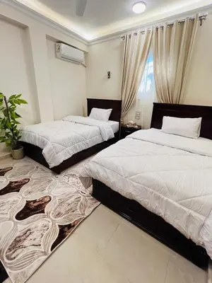 a bedroom with two beds and a window at Fontana Guste house in Luxor