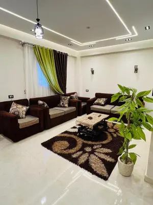 a living room with couches and a plant in it at Fontana Guste house in Luxor