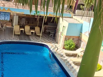 a large swimming pool with chairs and a table at Villa Joanna in Luxor