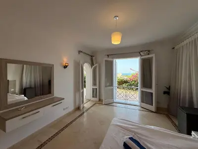 a bedroom with a large mirror and a large window at Hillside 4BR Villa, El Gouna Getaway in Hurghada