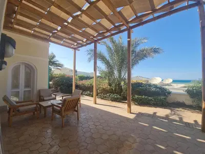 a patio with a table and chairs and a view of the ocean at Hillside 4BR Villa, El Gouna Getaway in Hurghada