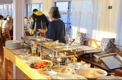 a buffet line with plates of food on a table at Cobra Nile Sails - Tranquility in Luxor