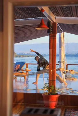 a person holding an umbrella on the deck of a boat at Cobra Nile Sails - Tranquility in Luxor