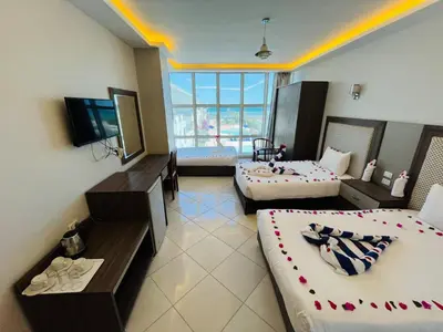 a hotel room with two beds and a television at Elite Sea Sky Resort in Hurghada