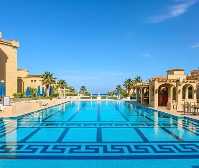a swimming pool in a resort with palm trees at Selena Bay Prime Stays in Hurghada