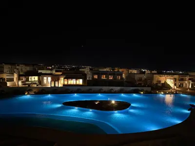 a swimming pool at night with blue lights at Makadi Heights Resort in Hurghada