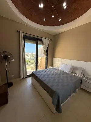 a bedroom with a bed and a large window at Makadi Heights Resort in Hurghada