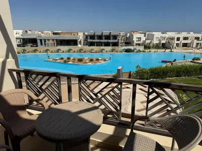 a balcony with a table and chairs and a swimming pool at Makadi Heights Resort in Hurghada