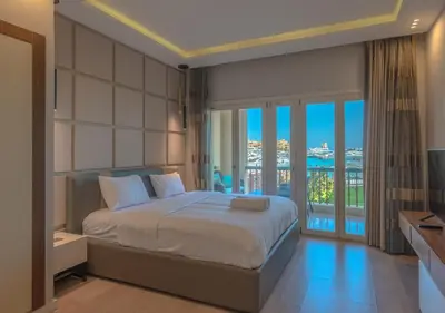 a bedroom with a large bed and a balcony at Upscale 2BR Mosaique Marina Stay, Yachts & Sea Views in Hurghada