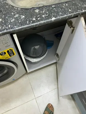 a person standing in a kitchen next to a microwave at شقة صغيرة جميلة امام مارينا الغردقة in Hurghada