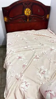 a bed with a blanket with flowers on it at Diebo in Aswan
