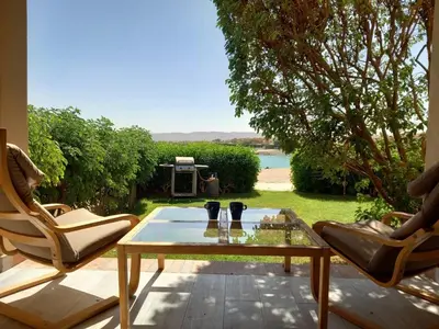 a patio with a coffee table and two chairs at Peaceful & bright lagoon escape - Shared infinity Pool - 1BR - Sabina, El Gouna in Hurghada