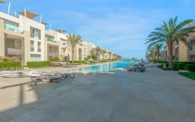 a resort with a swimming pool and palm trees and buildings at New 1BR Apartment in Mangroovy El Gouna Pool, Beach, The Red Sea in Hurghada