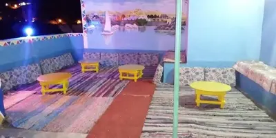 a room with two tables and two yellow tables at Nubian house in Jazīrat Salūjah