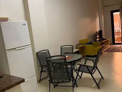 a kitchen with a table and chairs and a refrigerator at One-Bedroom Chalet with Side Sea View , Turtles Beach C23 in Hurghada