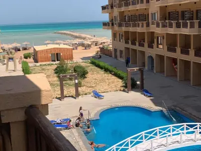 a view of a resort with a swimming pool and the beach at One-Bedroom Chalet with Side Sea View , Turtles Beach C23 in Hurghada