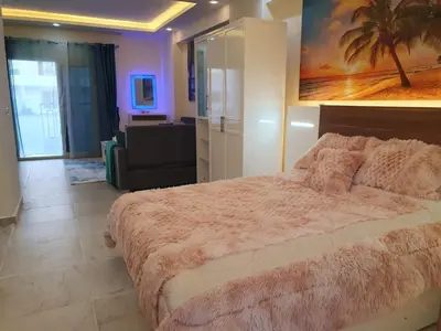 a bedroom with a large bed and a living room at Mirage Bay Resort Aquapark Ghada Suite in Hurghada