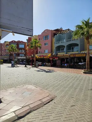 a street in a city with palm trees and buildings at Simplestays Hurghada in Hurghada