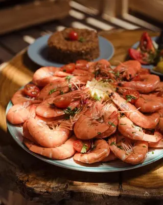a plate of shrimp on a table with a cake at رحلات بحرية دولفين وغواصة وجزر in Hurghada