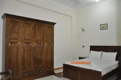 a bedroom with a bed and a wooden cabinet at White Villa in Luxor