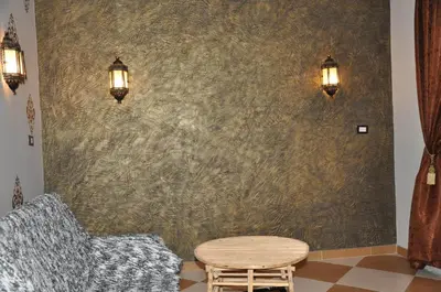 a room with two chairs and a table and a wall at White Villa in Luxor