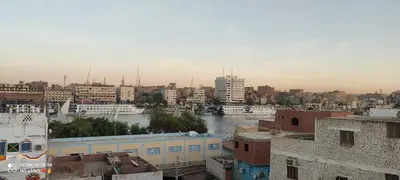 a view of a city with a river and buildings at SolNest Guest House in Jazīrat Aswān