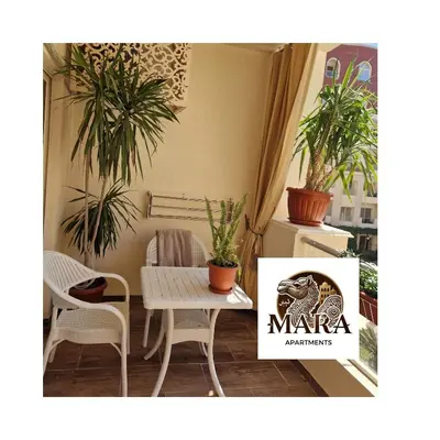 a table and chairs in a room with plants at MARA Apartments Florenza Khamsin in Hurghada