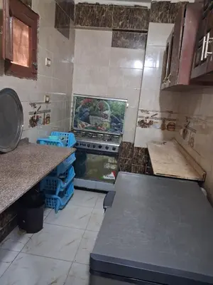 a kitchen with a stove top oven in a kitchen at Aswan in Naj‘ al Maḩaţţah