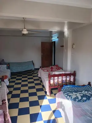 a room with two beds and a checkered floor at New Alsalam Hotel in Luxor