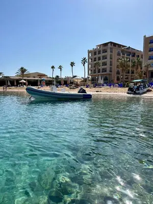 a boat in the water next to a beach at Large Studio Beach & Pool Hurghada - Wifi in Hurghada